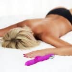Onani: Kvinne ligger på sengen med en vibrator etter å ha onanert.