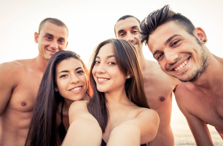 Swinging: Swinger gruppe har det kjekt på stranden. Tre menn og to damer.