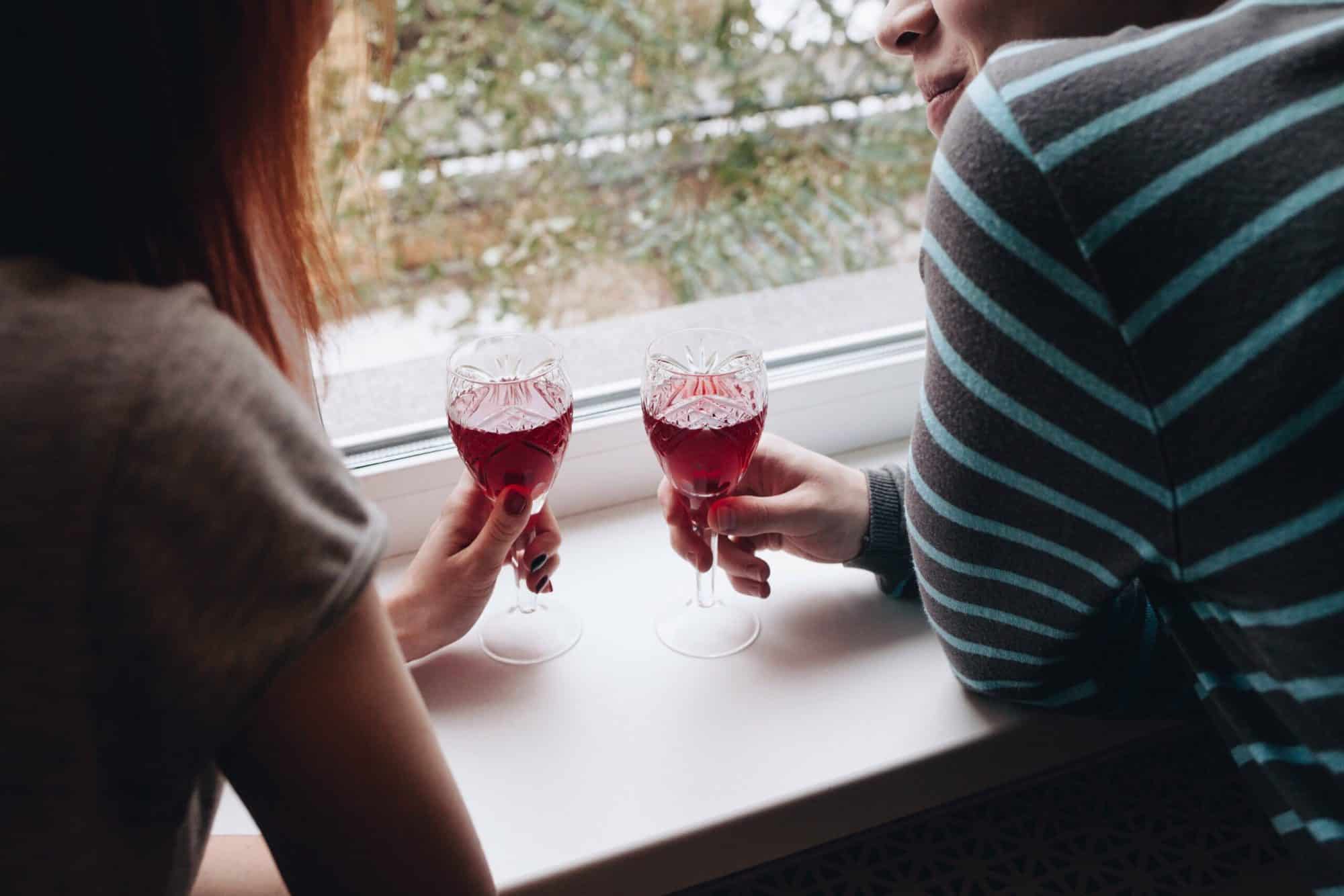 Kommunikasjon om sex: Par som snakker sammen og har hvert sitt glass i hånden