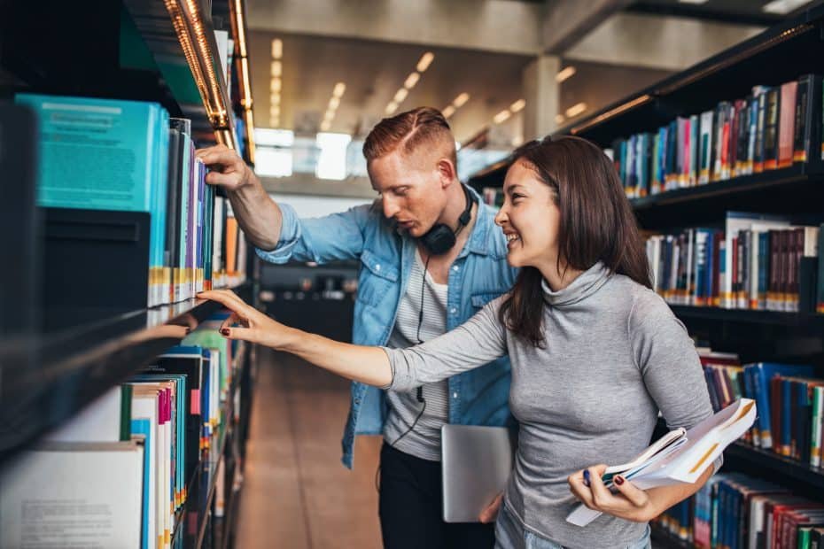 Erotisk novelle illustrasjon: To studenter står i biblioteket og ser på bøker imens de kjenner på en tiltrekning til hverandre.