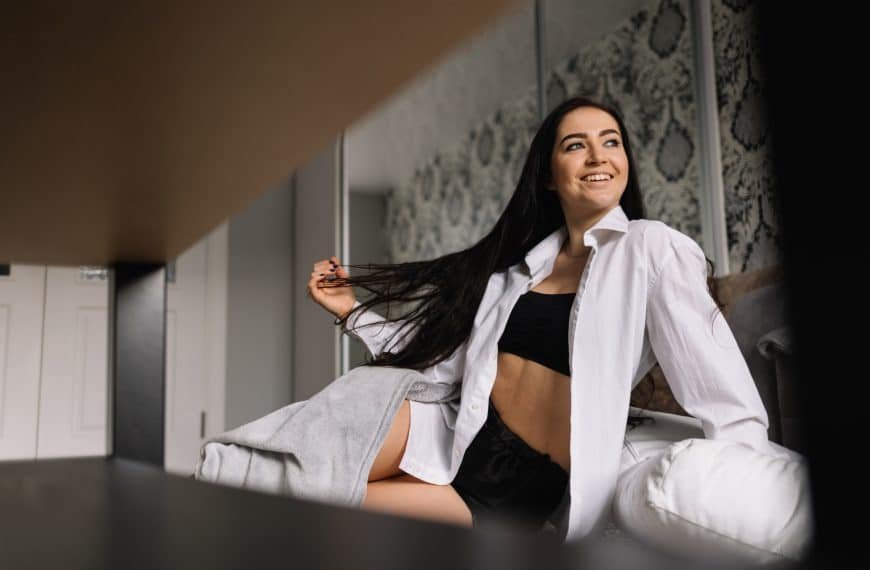 Sexy dame sitter på sengen