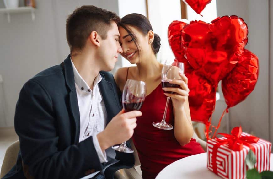 Valentinsdagen: Illustrasjon med vakkert par i dress og kjole, drikker vin, flørter, hjerteballonger.