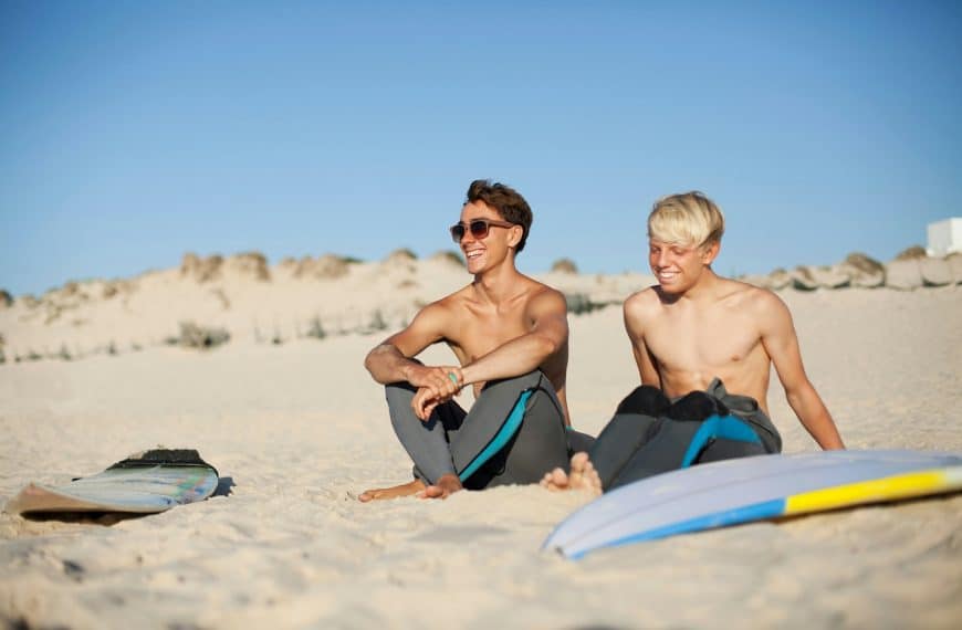 Two young surfers sitting on a beach