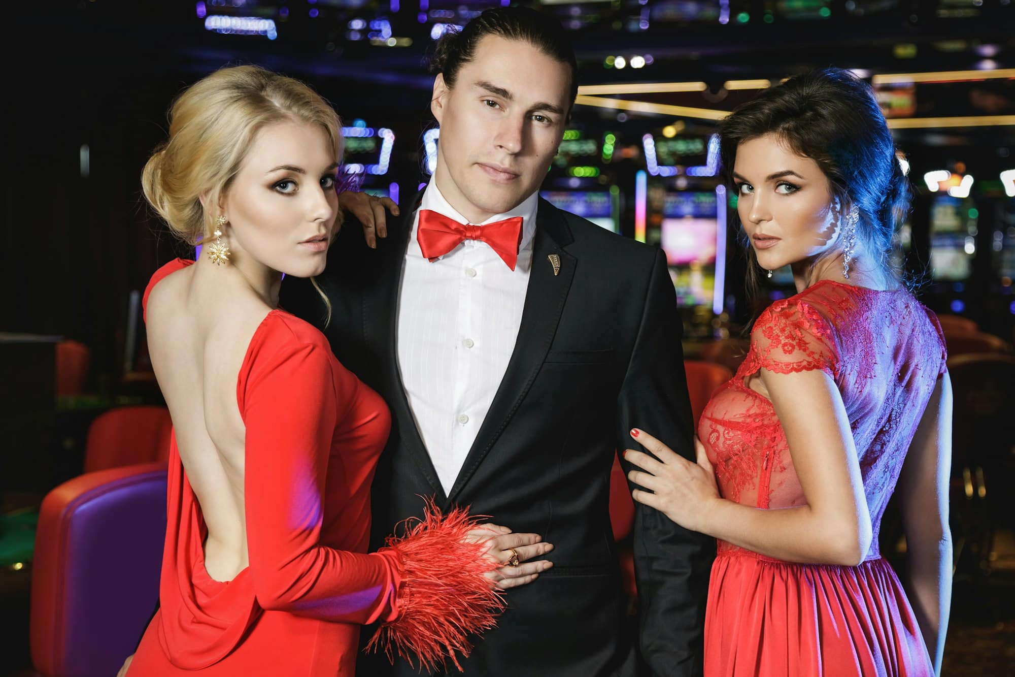 Confident man and two beautiful women in the casino