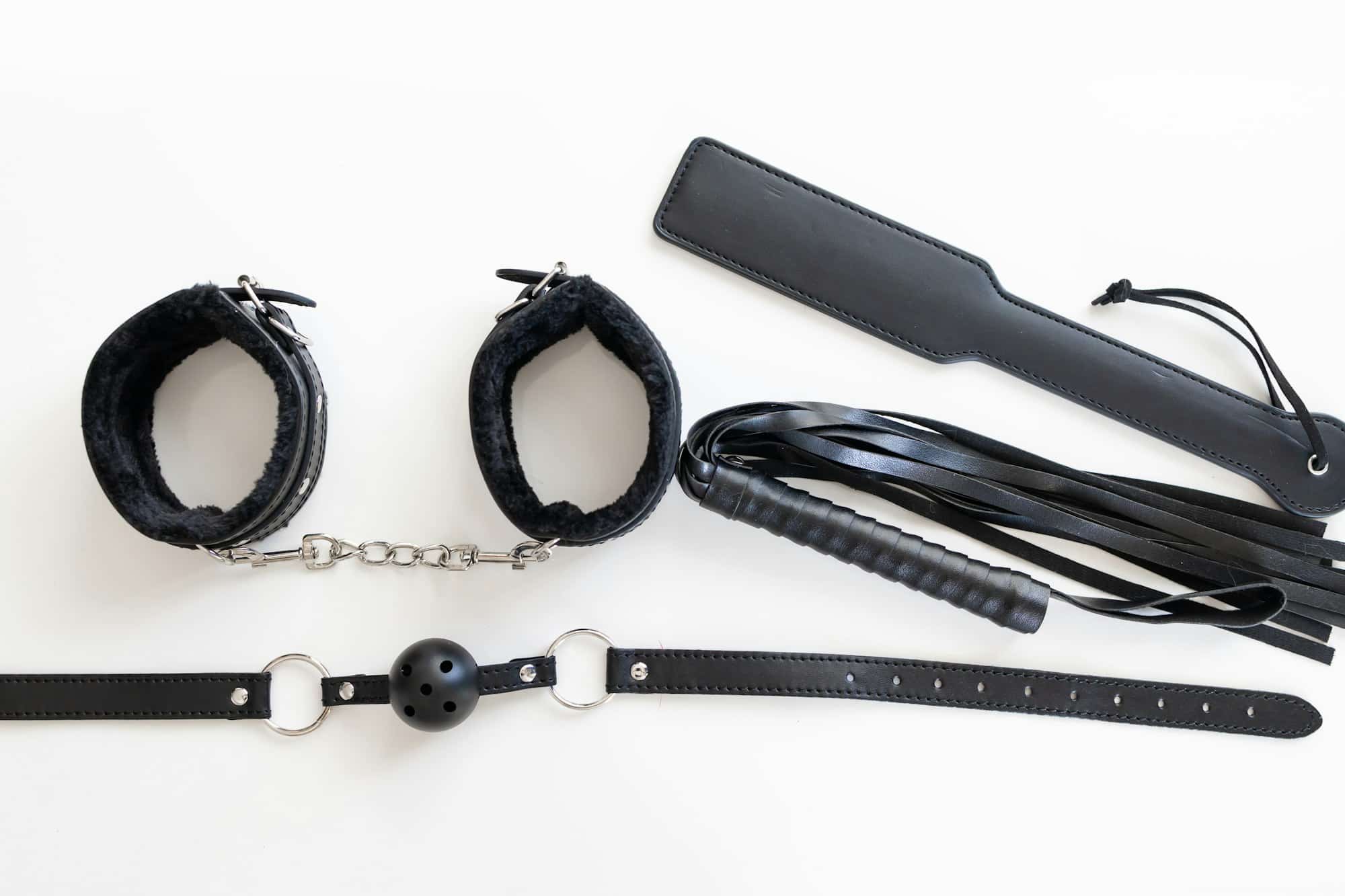 BDSM utstyr: Mansjetter, paddle, flogger og gag