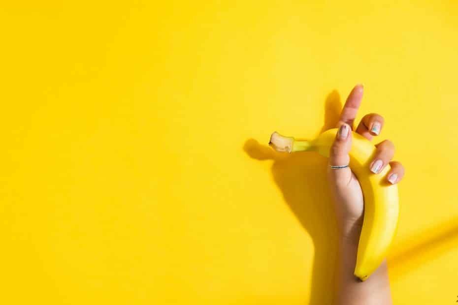 Ripe fresh banana fruit in a woman's hand with shadow