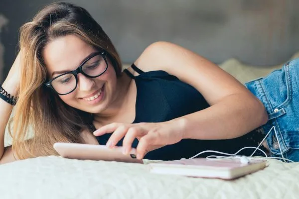 Sexy dame med telefon i sengen