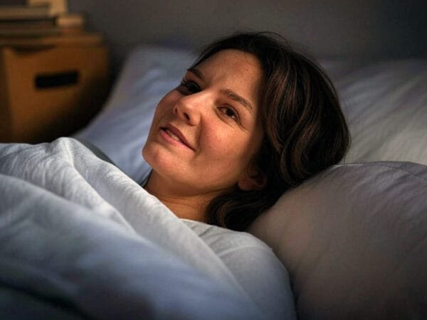 Dame som ligger i sengen og lytter til naboens sexlyder