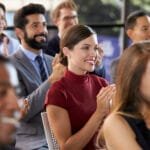 Sexy brunette sitter på en stol på en konferanse