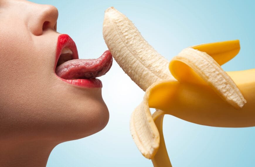 Sexy kvinne slikker en banan - antyder blowjob