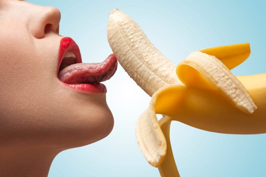 Sexy kvinne slikker en banan - antyder blowjob