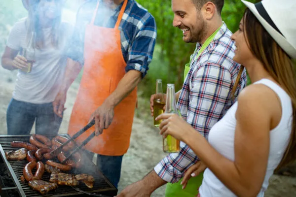 Vennepar står og griller