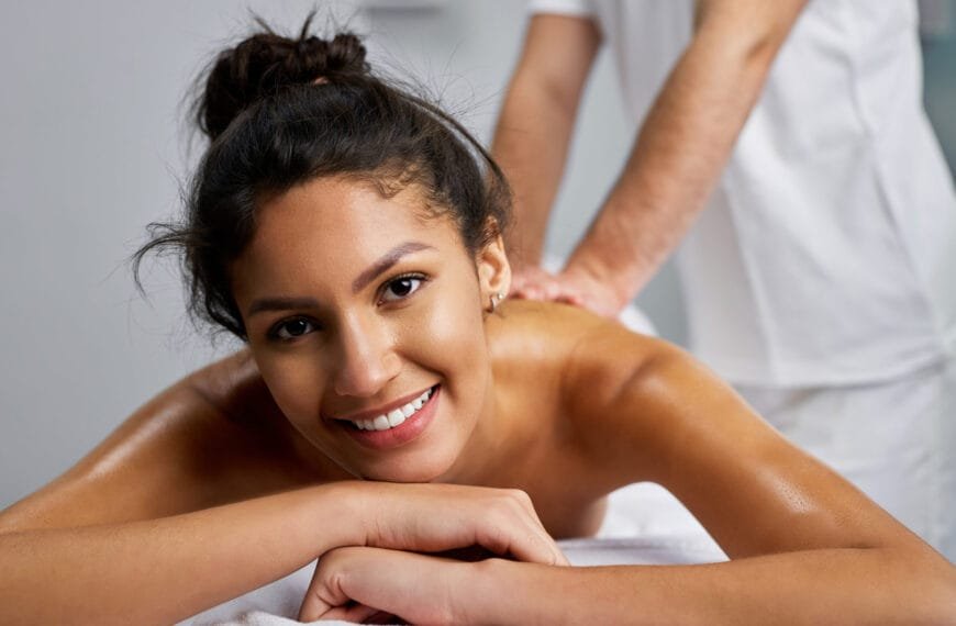 En vakker dame ligger på massasjebenken og mottar massasje fra en mann