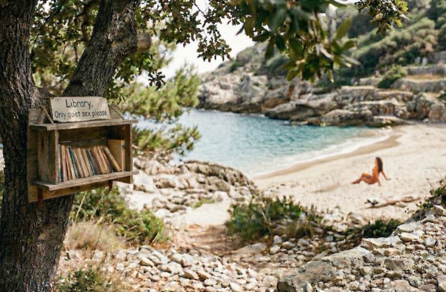 Naken kvinne på stranden, og bokhylle med tekstsen - library - only quiet sex please